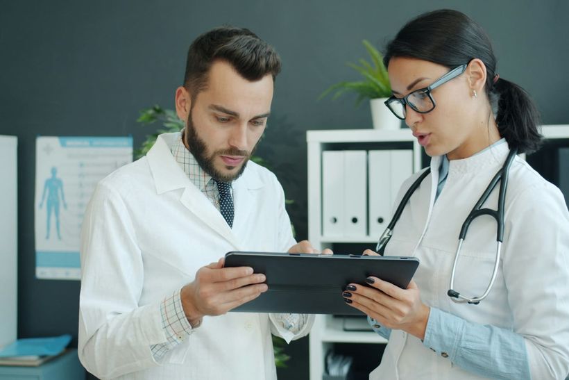 Healthcare professionals reviewing information on a tablet